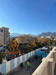 een menigte mensen die door een stad lopen met gebouwen bij Maison Micheloni Menton in Menton