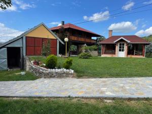 a house with a stone path in front of it at Domacinstvo Ilici ,Gunjaci in Valjevo