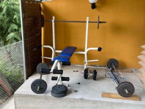 a gym with a chair and weights on the floor at Domacinstvo Ilici ,Gunjaci in Valjevo