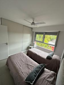 1 dormitorio con 2 camas y ventana en Centrico departamento de categoría en Chascomús