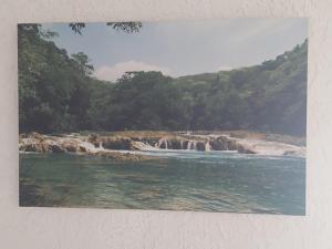 a painting of a beach with rocks and water at Casa Nopal Tu casa vacacional tipo hotel in Creel