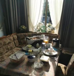 una sala de estar con sofá y mesa con comida. en B&B Klassiek, en Twijzelerheide