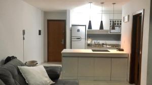 a kitchen with a couch and a kitchen with a refrigerator at Saint Sebastian Flat 615 - Com Hidro! até 4 pessoas, Duplex, no centro in Jaraguá do Sul