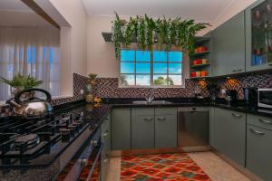 eine Küche mit grauen Schränken und einem Fenster in der Unterkunft Villa Tamar in Palm-Eagle Beach