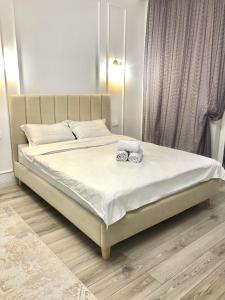 a bed with two slippers on it in a bedroom at Premium Apartments Esil Riverside in Astana