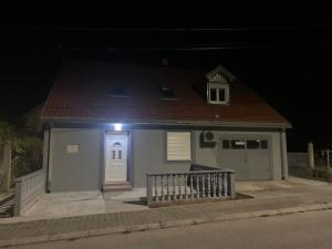 Una pequeña casa azul con una luz en la puerta. en Apartmani Vučinić, en Cetinje 1 foto más