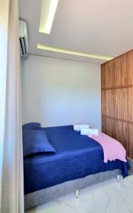 a bedroom with a bed with blue sheets and pillows at Flat Central em Cavalcante in Cavalcante