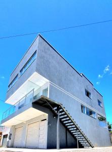 a gray building with a stairway leading up to it at Flat Central em Cavalcante in Cavalcante