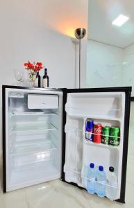 an open refrigerator filled with water and soda bottles at Flat Central em Cavalcante in Cavalcante