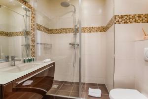 a bathroom with a shower and a sink and a toilet at La Villa Normande - One Bedroom in Deauville