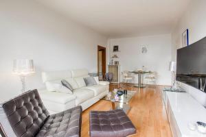 a living room with a white couch and a table at La Villa Normande - One Bedroom in Deauville