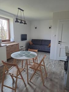 sala de estar con mesa, sillas y sofá en Apartament w Chęcinach, en Chęciny