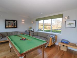 a living room with a pool table and a couch at Ferneytoun in Aboyne