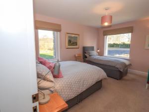 a bedroom with two beds and two windows at Ferneytoun in Aboyne