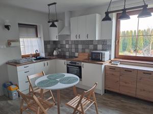 a kitchen with a table and chairs in a kitchen at Apartament w Chęcinach in Chęciny