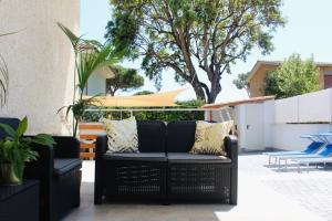 a patio with two wicker chairs and a table at Thalassa Casa Vacanza in Anzio