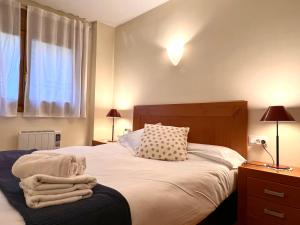 - une chambre avec un lit doté de draps blancs et une fenêtre dans l'établissement Apartament Boet - Ainet de Cardós, à Vall de Cardos