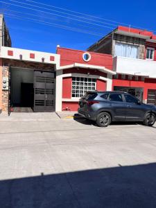 マサトランにあるMini casa llena de vidaのガレージ付き建物の前に駐車した車