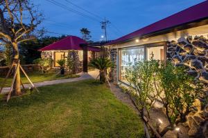 una casa con jardín por la noche en Juwoldam en Jeju