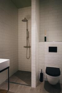 een badkamer met een zwart toilet en een douche bij Dudok Studio's Arnhem-Oosterbeek in Oosterbeek