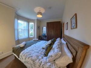 a bedroom with a large bed with a wooden headboard at The Ingleside Apartment in Basingstoke