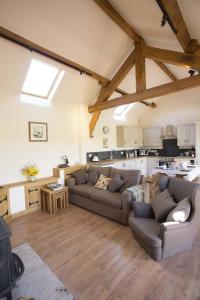 sala de estar con 2 sofás y cocina en Fuesli Lodge - Boutique Cottage at Harrys Cottages en Pen y Clawdd