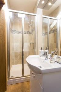 y baño con ducha, lavabo y lavamanos. en Fuesli Lodge - Boutique Cottage at Harrys Cottages en Pen y Clawdd