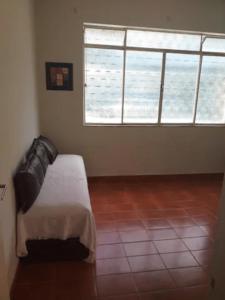 1 dormitorio con cama y ventana grande en Apartamento(1) inteiro com sala reversivel en Volta Redonda