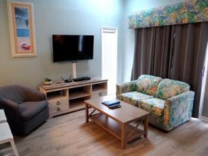 a living room with a couch and a chair and a tv at 1J Golf Colony Resort in Family Friendly Surfside in Myrtle Beach
