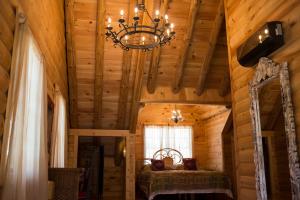 a bedroom in a log cabin with a chandelier at Log Country Inn Bed and Breakfast of Ithaca in Spencer