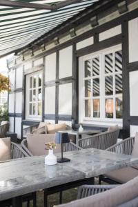 a patio with a table and chairs and windows at Boutique-Hotel Weigels Bergfreiheit in Winterberg +81 photos