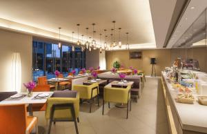 a restaurant with tables and chairs and a buffet at Citadines Intime City Hangzhou in Hangzhou