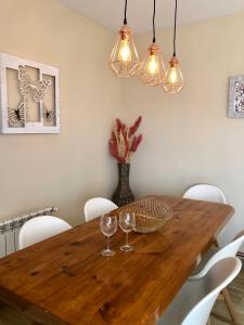 una mesa de comedor con copas de vino y luces en Casa El Tejar en Las Navas del Marqués