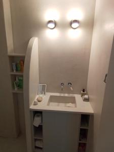 a bathroom with a sink with two lights above it at Sunloft-Paros in Naousa