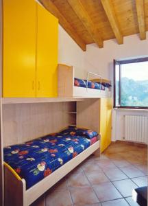 a bedroom with a bed with yellow cabinets and a window at Residence Garden in Tignale