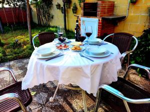 La Casa del Naturalista في البوسكي: طاولة مع أطباق من الطعام وكؤوس من النبيذ