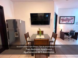 ein Esszimmer mit einem Tisch und einem Kühlschrank in der Unterkunft Cárdenas Suites in Puerto Vallarta