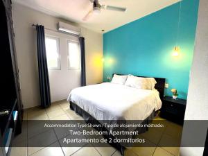 ein Schlafzimmer mit einem Bett und einer blauen Wand in der Unterkunft Cárdenas Suites in Puerto Vallarta