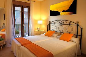 馬德里的住宿－Bien situado y cómodo，一间卧室配有带橙色枕头的床