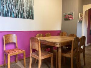 una sala da pranzo con tavolo e sedie in legno di Gîte Vassy-Etaule Spa Privatif 