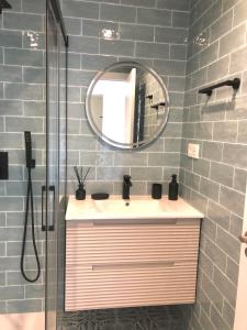 bagno con lavandino, specchio e doccia di SUITE PLAYA GIJON CENTRO, apartamento nuevo, 5 huéspedes VUT-3622-AS a Gijón