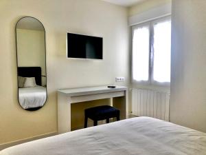 - une chambre avec un lit, un miroir et un bureau dans l'établissement SUITE PLAYA GIJON CENTRO, apartamento nuevo, 5 huéspedes VUT-3622-AS, à Gijón