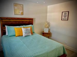 a bedroom with a bed with blue and orange pillows at Coastal Escape: Sleek King Suite on Half Acre in Gulfport
