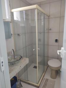uma casa de banho com um chuveiro, um WC e um lavatório. em ** SUITE PRIVATIVA PRAIA DO FORTE CABO FRIO ** em Cabo Frio