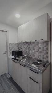 een keuken met witte kasten en een fornuis met oven bij Vucinic Studio Apartment in Cetinje