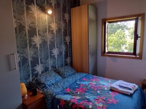 ein Schlafzimmer mit einem Bett mit blauer Decke und einem Fenster in der Unterkunft Moinho do ribeirinho, renovado vintage in Campos de Sá