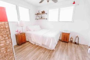 a bedroom with a white bed and two windows at ____Cute Plantation House in Kailua with AC!!_____ in Kailua