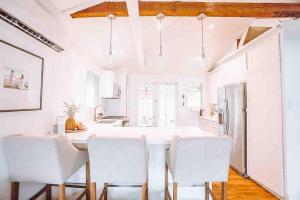 a kitchen with white chairs and a large white island at ____Cute Plantation House in Kailua with AC!!_____ in Kailua