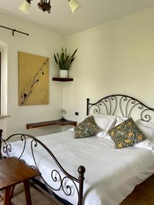 um quarto com uma cama branca com duas almofadas em Casale Viridi - nel fresco delle colline Umbre em Narni