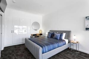 a bedroom with a large bed with blue pillows at Port Lincoln Shark Apartment 4 in Port Lincoln